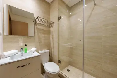 a bathroom with a shower and a toilet and a sink at Green Side Golf 3 B.R Apartment in Marrakech