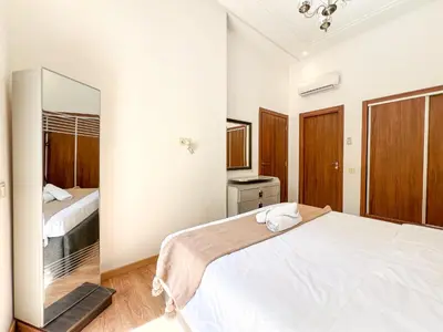 a bedroom with a large white bed and a mirror at Cozy apartment pool marrakech morocco in Marrakech