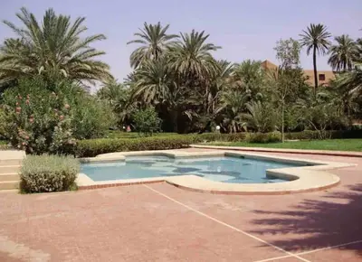 a swimming pool in a yard with palm trees at Appart-Oasis/3 Piscines/2 Terrasses in Marrakech