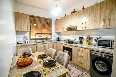 a kitchen with wooden cabinets and a table with chairs at The Skyline Stay in Marrakech