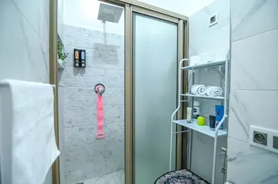 a shower with a pink shower head in a bathroom at The Skyline Stay in Marrakech