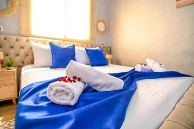 a bed with blue and white sheets and towels on it at The Skyline Stay in Marrakech