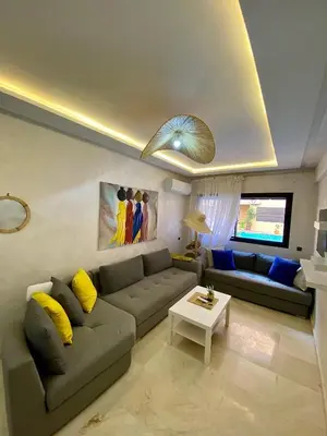 a living room with a couch and a table at Appartement 2 chambres vue Piscine à Guèliz en face la gare de train marrakech in Marrakech