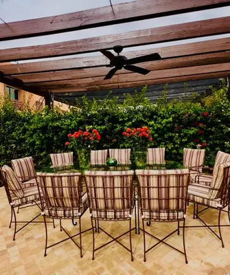 a patio with a table with chairs and a ceiling fan at Villa Jenna in Marrakech