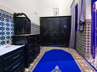 a bathroom with black cabinets and a blue rug at Riad Sultana - 10 min à pied de Jemaa El Fna in Marrakech