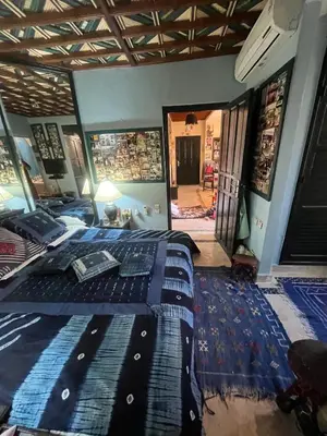 a bedroom with a bed with a blue comforter on it at Penthouse Jaccuzi Atlas Marrakech in Marrakech