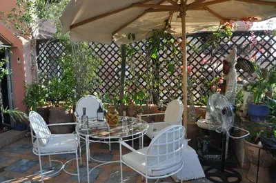 a patio with a table and chairs and an umbrella at Penthouse Jaccuzi Atlas Marrakech in Marrakech