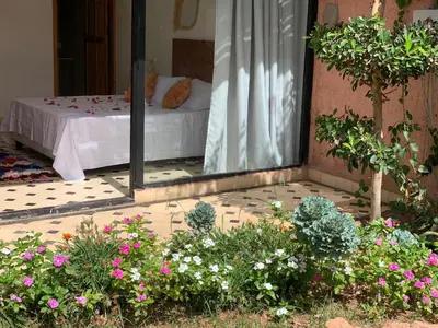 a bedroom with a bed in a room with flowers at La villa Berbère - Famille uniquement in Marrakech