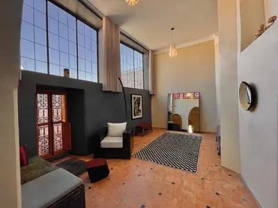 a large living room with a couch and a chair at Riyad Lion Rouge in Marrakech