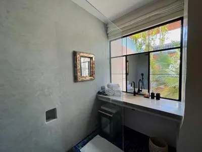 a bathroom with a sink and a window at Riyad Lion Rouge in Marrakech