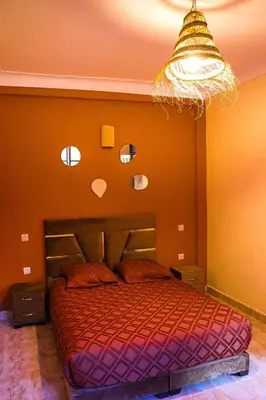 a bedroom with a bed and a chandelier at Appartement MSholidays Gazelle Marrakech in Marrakech