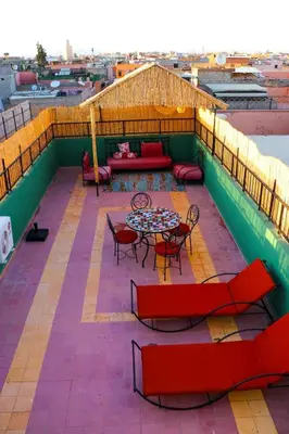 a patio with a table and chairs on a roof at Appartement MSholidays Gazelle Marrakech in Marrakech