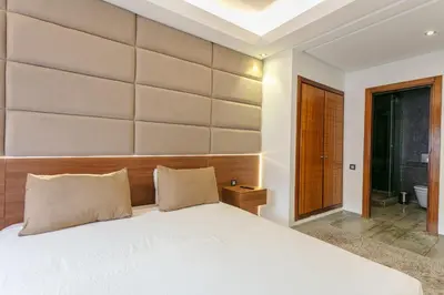 a bedroom with a large bed with a large headboard at The Gallery Suite – Marrakech Centre in Marrakech