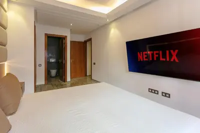 a bedroom with a bed with a television on the wall at The Gallery Suite – Marrakech Centre in Marrakech