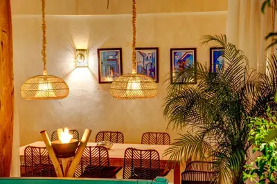 a dining room with a table with chairs and pendant lights at Riad Bella Kasbah in Marrakech