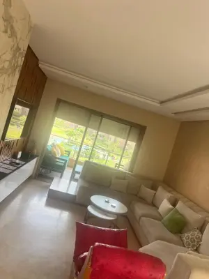 a living room with a couch and a table at Prestigia Golf Vue Atlas et Piscine in Marrakech