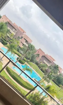 a view of a pool from a window at a resort at Prestigia Golf Vue Atlas et Piscine in Marrakech