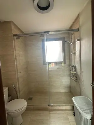 a bathroom with a glass shower with a toilet at Prestigia Golf Vue Atlas et Piscine in Marrakech