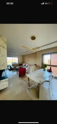 a large living room with a table and chairs at Prestigia Golf Vue Atlas et Piscine in Marrakech