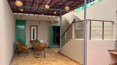 a room with a staircase and a table and chairs at Luxurious Villa with private pool, Jacuzzi & Cuisinière in Marrakech