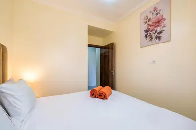 a bedroom with a white bed with an orange towel on it at Appartement 2 chambres Aéroport in Marrakech