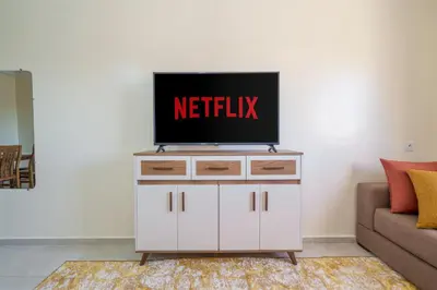 a tv on top of a white dresser in a living room at Appartement 2 chambres Aéroport in Marrakech