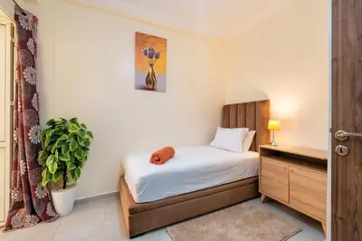 a small bedroom with a bed and a plant at Appartement 2 chambres Aéroport in Marrakech