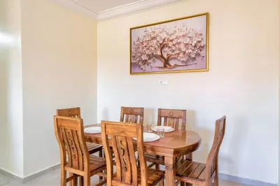 a dining room with a wooden table and chairs at Appartement 2 chambres Aéroport in Marrakech