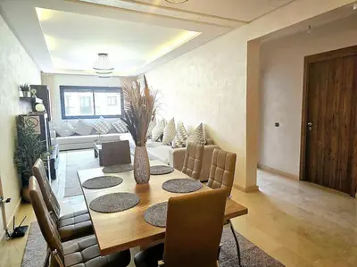 a dining room with a table and a couch at appartement cosy plein centre in Marrakech