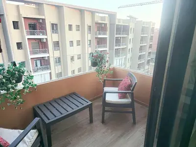 a balcony with a chair and a bench on a building at appartement cosy plein centre in Marrakech