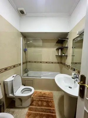 a bathroom with a toilet and a sink and a tub at Appartement piscine in Marrakech