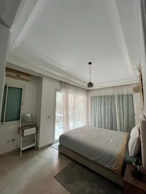 a bedroom with a bed and a large window at Appartement piscine in Marrakech