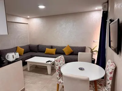 a living room with a couch and a table at C-Appartement de luxe plein centre de gueliz avec piscine parking wifi netflix in Marrakech