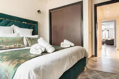 a bedroom with a large bed with towels on it at C-Appartement de luxe plein centre de gueliz avec piscine parking wifi netflix in Marrakech