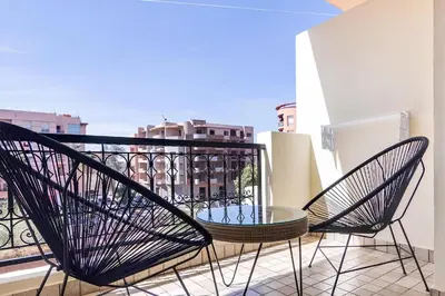 two chairs and a table on a balcony at C-Appartement de luxe plein centre de gueliz avec piscine parking wifi netflix in Marrakech