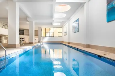 a large swimming pool with blue water in a building at C-Appartement de luxe plein centre de gueliz avec piscine parking wifi netflix in Marrakech