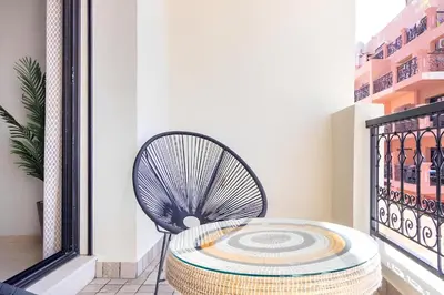 a round rattan table on a balcony at C-Appartement de luxe plein centre de gueliz avec piscine parking wifi netflix in Marrakech