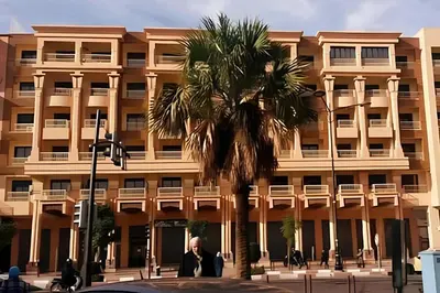 a palm tree in front of a building at C-Appartement de luxe plein centre de gueliz avec piscine parking wifi netflix in Marrakech