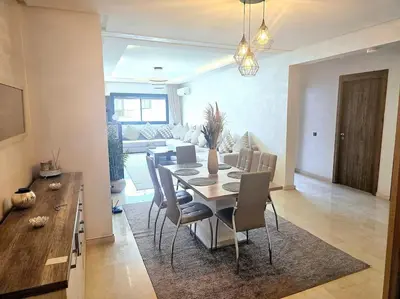 a dining room and living room with a table and chairs at appartement cosy plein centre in Marrakech