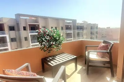 a balcony with a table and chairs and a plant at appartement cosy plein centre in Marrakech