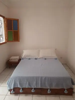 a bedroom with a bed with a blue blanket at Riad Sun and Swim Marrakech in Marrakech