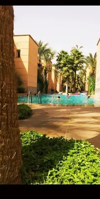 a swimming pool with people in the water at Riad Sun and Swim Marrakech in Marrakech