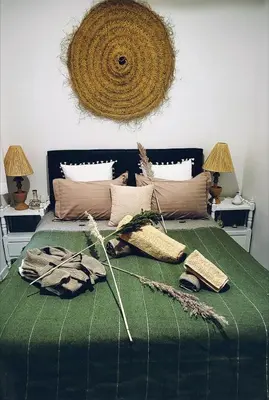 a bed with a green comforter with some items on it at Riad traditionnel de charme 3 chambres in Marrakech