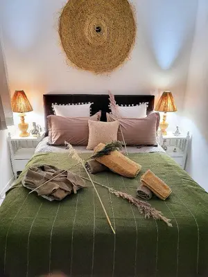 a bedroom with a large green bed with some pillows at Riad traditionnel de charme 3 chambres in Marrakech