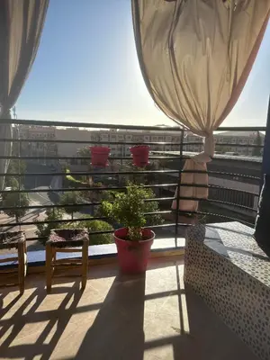 a balcony with a potted plant on a building at Séjour lumineux confort et design in Marrakech