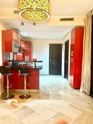 a kitchen with red walls and a bar with stools at Séjour lumineux confort et design in Marrakech