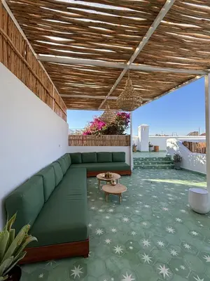 a living room with a green couch and a table at Neroli le Riad, idéalement situé in Marrakech