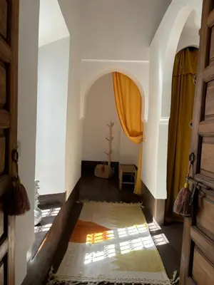 a hallway with an archway and a door at Neroli le Riad, idéalement situé in Marrakech