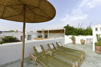 two chairs and an umbrella on a patio at Neroli le Riad, idéalement situé in Marrakech
