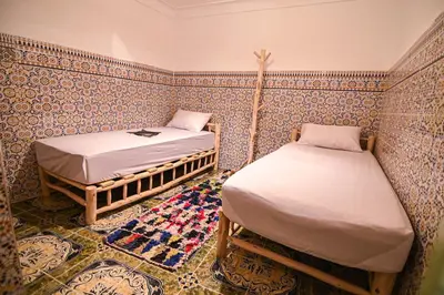 a room with two beds and a rug at Oasis Medina Hostel in Marrakech